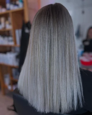 Steil asblond haar met babylights en balayage, van donkere aanzet naar lichte punten